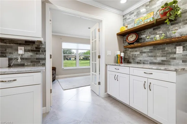 Kitchen with white cabinetry and tasteful backsplash