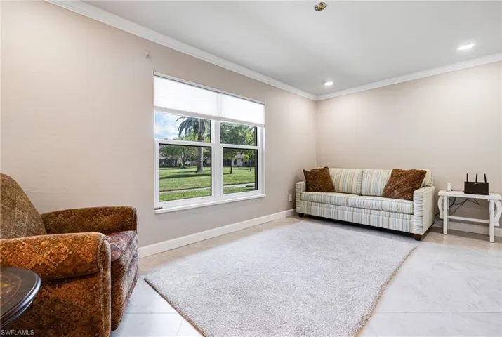 Living room with ornamental molding and light tile patterned floors