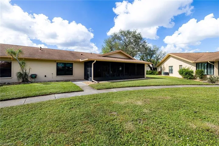 Ranch-style house featuring a front lawn and a sunroom