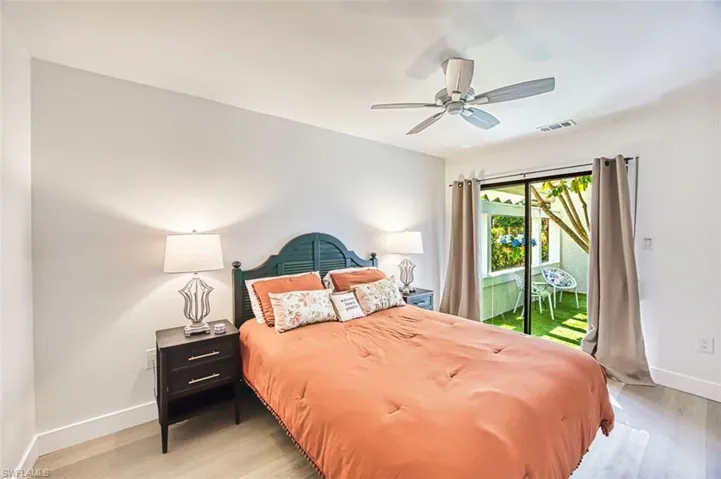 Bedroom with access to outside courtyard, baseboards, wood finished floors, and a ceiling fan
