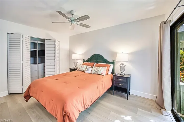 Bedroom featuring baseboards, light vinyl plank floors, and multiple windows