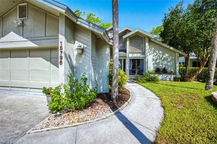 View of exterior entry with a yard and a garage