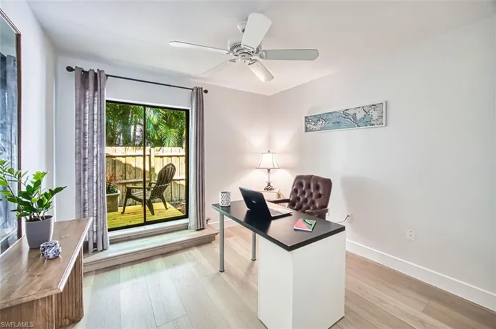 Office space featuring a ceiling fan, light wood-type flooring, and baseboards