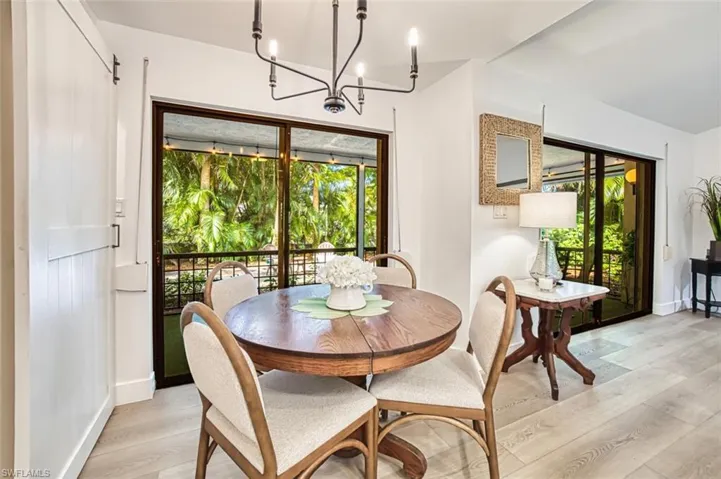 Dining room with a chandelier, light wood finished floors, and baseboards