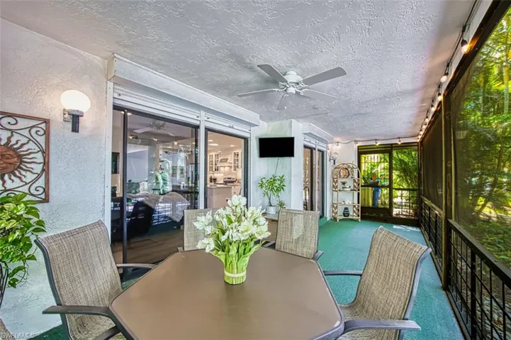 Sunroom or lanai with ceiling fan and outdoor dining space