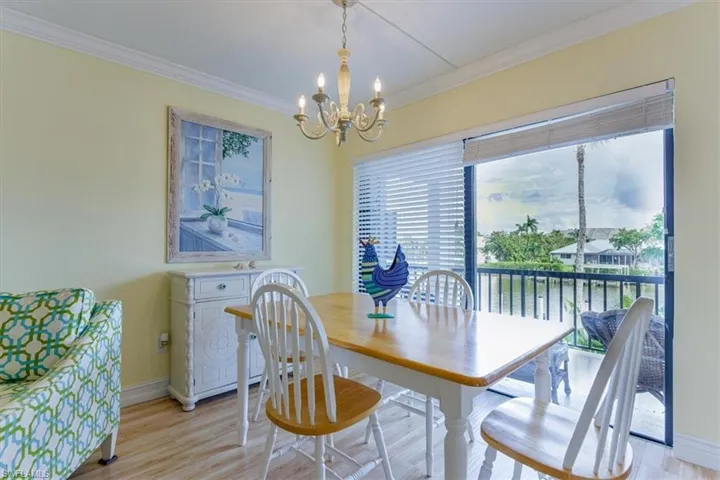 Dining room featuring crown molding, light wood-style floors, and a chandelier