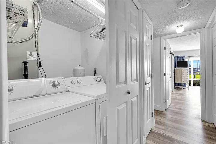Utility closet is conveniently located between the 2 bedrooms. Air handler and water heater are behind the washer and dryer. A linen closet is also in the hall. Waterproof laminate was installed in the hallways, bedrooms, and kitchen.