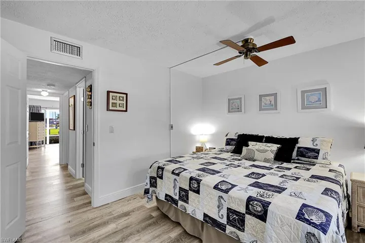 Second (guest) bedroom measures a spacious 14'x11'. Laundry, linen closet, guest bathroom, and interior storage room is in hallway. Laminate wood flooring is in both bedrooms and hallway.