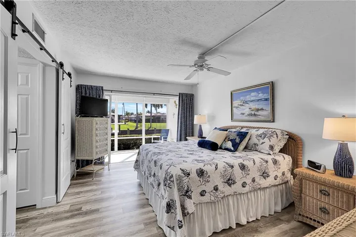 Beautiful, spacious primary bedroom has laminate wood flooring, an ensuite bathroom, and slider access to the lanai. Condo is selling Turnkey-furnishings and linens included.