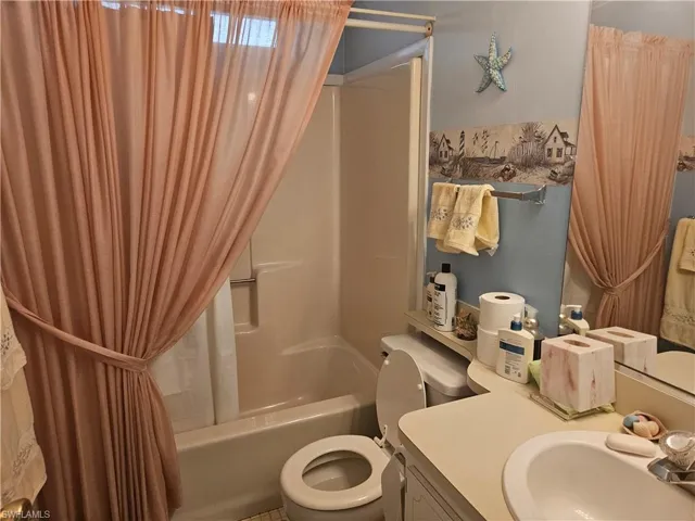 Full bathroom featuring shower / bath combo, sink, and toilet