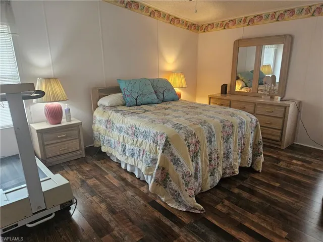 Bedroom with dark hardwood / wood-style floors