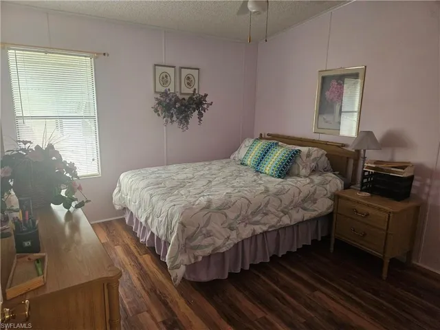 Bedroom featuring dark hardwood / wood-style floors and a textured ceiling