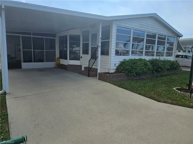 View of front of home with a carport and a sunroom