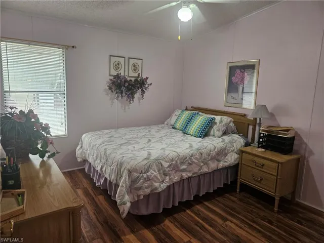 Bedroom featuring ceiling fan, dark wood-type flooring, and a textured ceiling