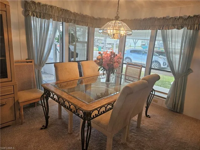 Dining area featuring a chandelier and carpet flooring