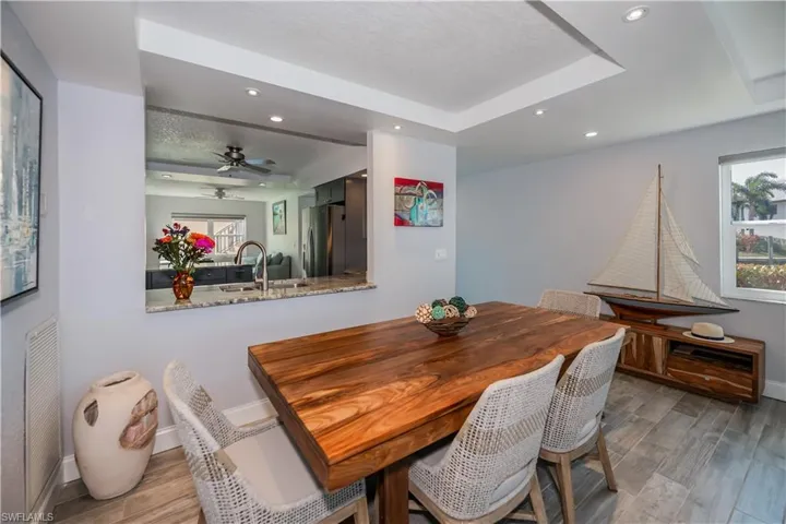 Dining space with ceiling fan, a tray ceiling, and sink