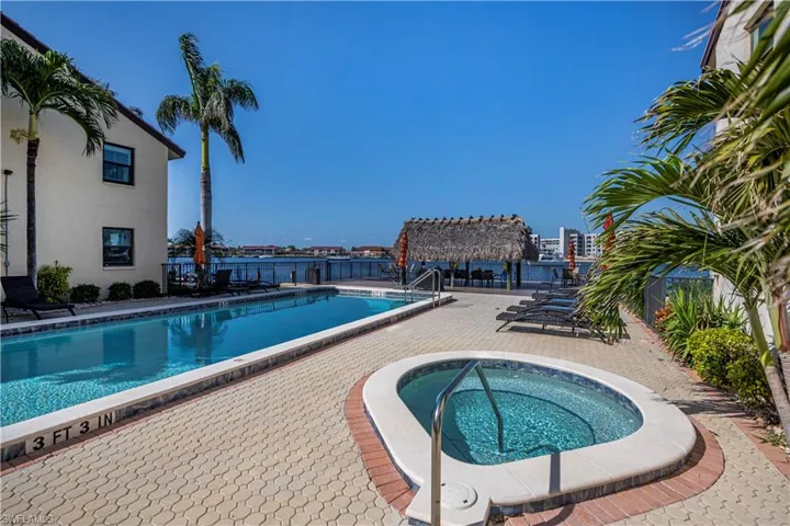 View of swimming pool featuring a hot tub and a patio area