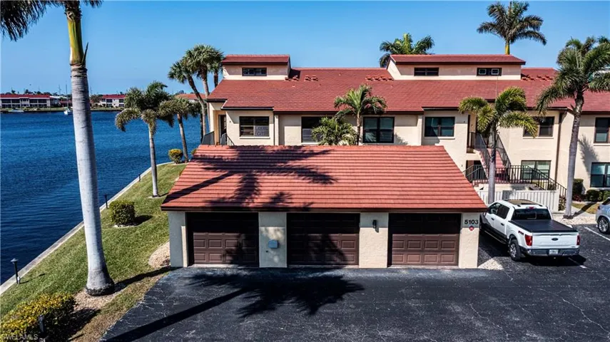 View of front of house with a garage and a water view