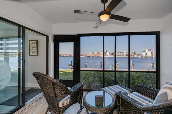 Sunroom featuring ceiling fan and a water view