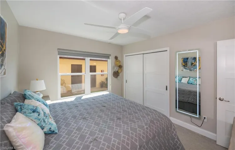 Carpeted bedroom featuring a closet and ceiling fan