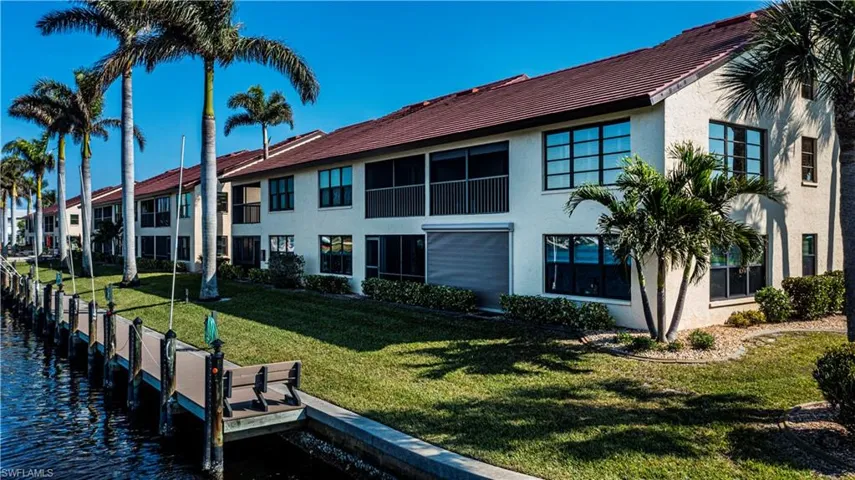 Back of house with a yard and a water view