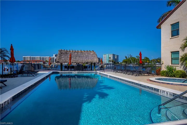 View of swimming pool featuring a patio area and a hot tub