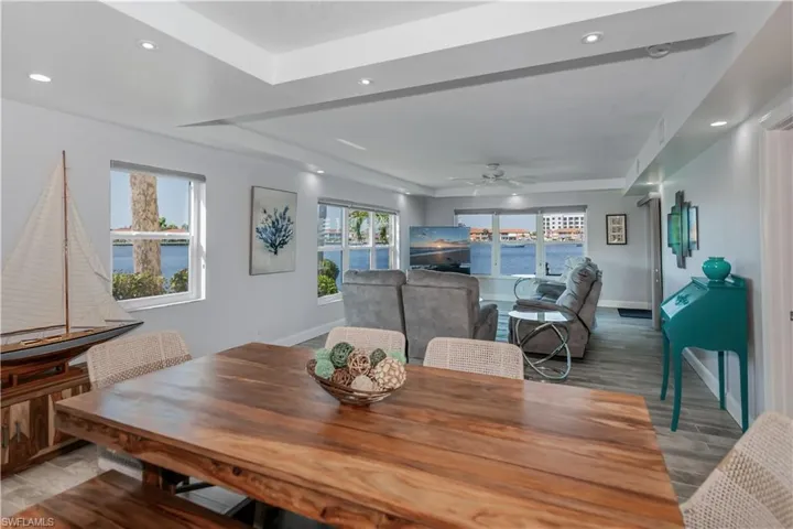 Dining space featuring ceiling fan, hardwood / wood-style flooring, and a tray ceiling