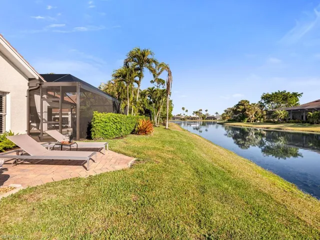 View of yard with a lanai, a patio, and a water view