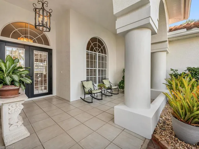 View of exterior entry featuring french doors and covered porch