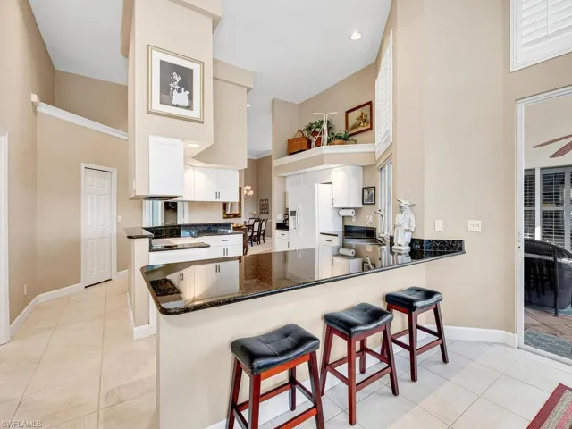 Kitchen featuring white cabinetry, sink, kitchen peninsula, and light tile patterned flooring