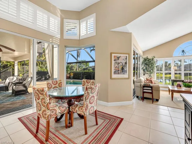 Tiled dining area with a healthy amount of sunlight and high vaulted ceiling