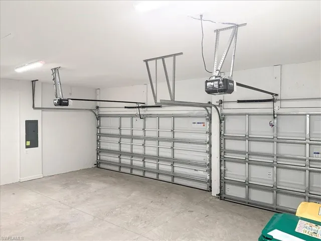 Garage featuring electric panel and a garage door opener