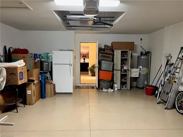 Garage featuring electric water heater and white fridge