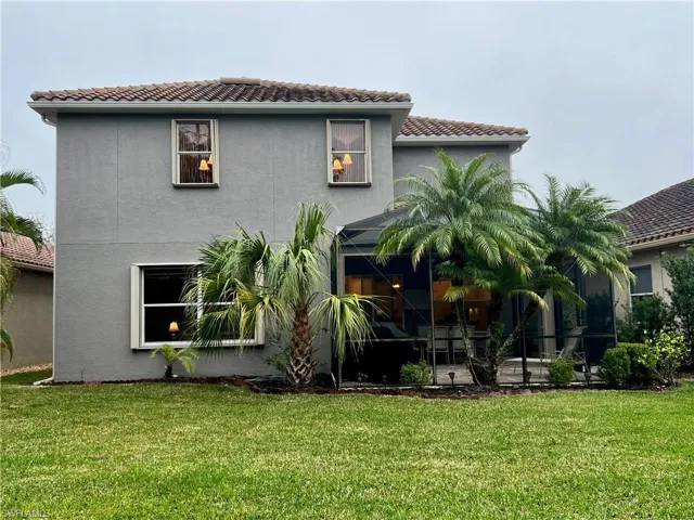 Rear view of property with a yard