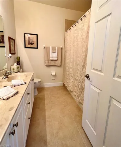Bathroom featuring double sink, tiled floor and combined tub and shower