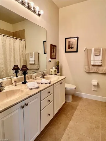 Bathroom featuring double sink, tiled floor and combined tub and shower