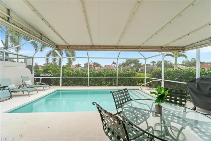Swimming pool featuring a lanai, a sunroom, and area for grilling