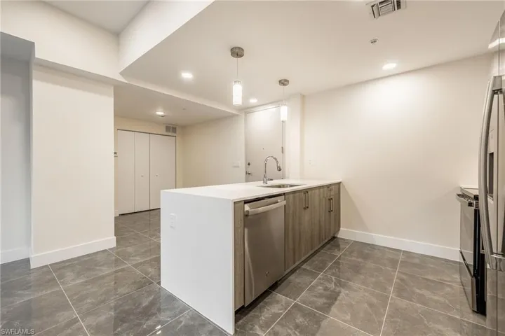 Kitchen featuring a sink, a peninsula, stainless steel appliances, baseboards, and visible vents