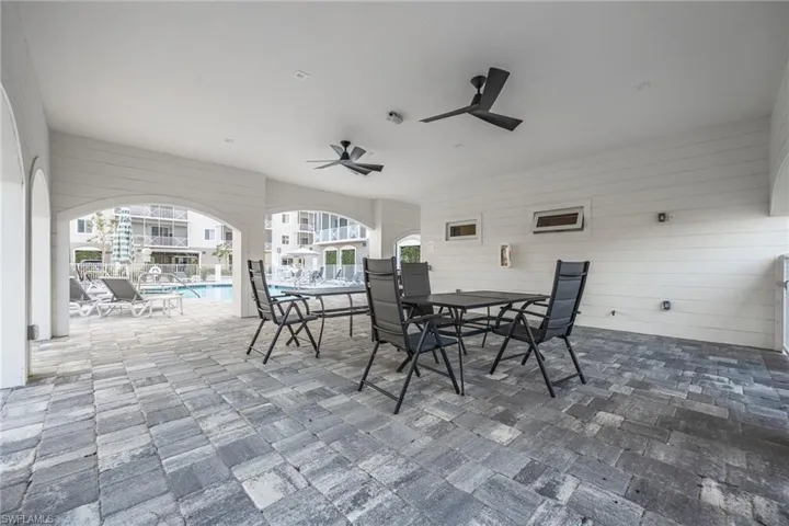 View of patio / terrace with outdoor dining area, a ceiling fan, and a community pool