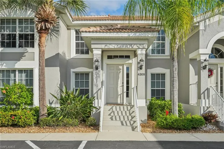 Entrance to property featuring stucco siding, a tiled roof, and uncovered parking