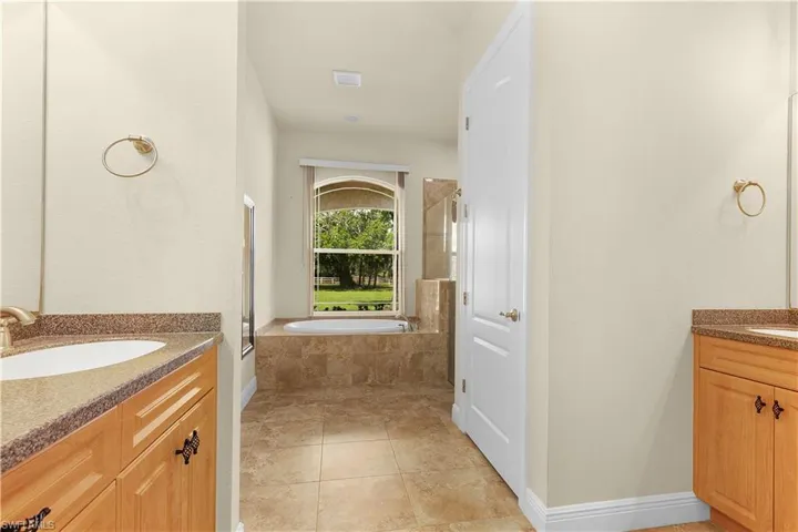 Plenty of natural light in the primary suite with a large walk in shower with a frameless shower enclosure.