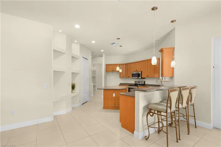 Large kitchen with a small island and breakfast bar that is open to the family room.