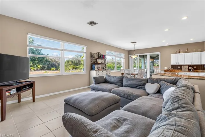 Living area with light tile patterned floors and recessed lighting