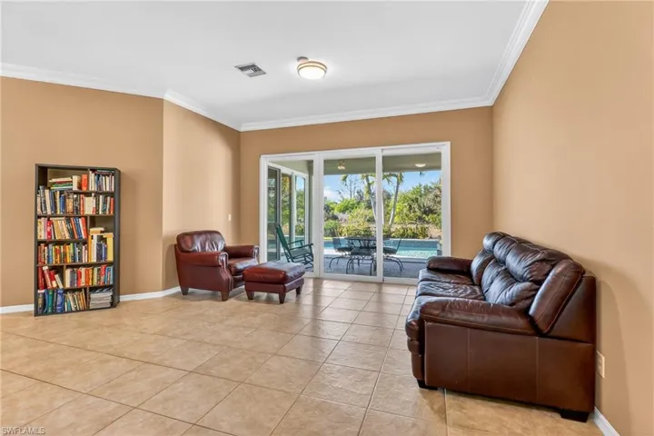 Living area with ornamental molding and light tile patterned flooring