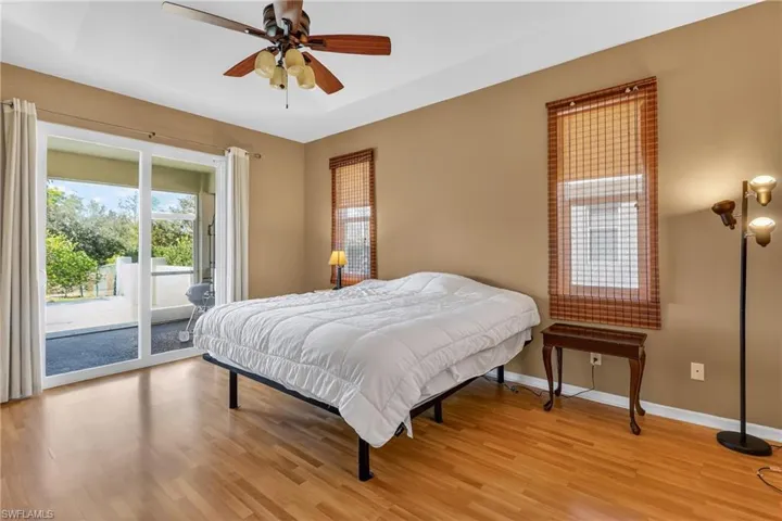 Bedroom featuring access to exterior, light wood-type flooring, and a ceiling fan