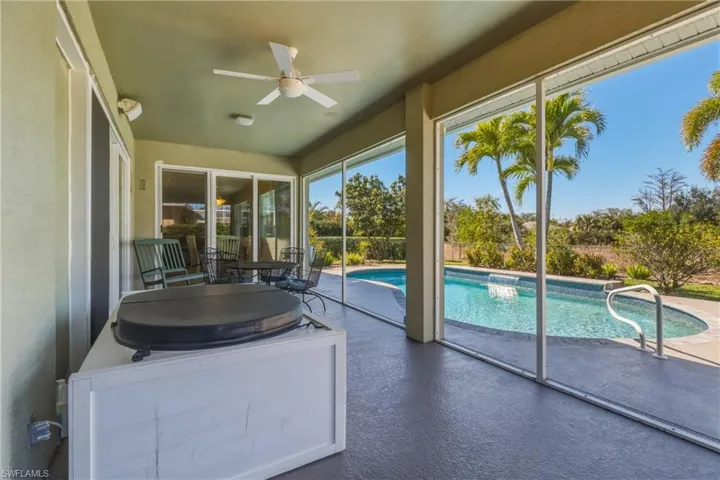 Sunroom featuring ceiling fan, a pool, and a patio