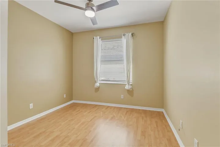 Empty room with wood finished floors and a ceiling fan