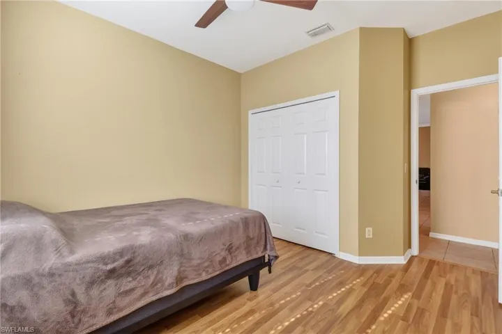 Bedroom with wood finished floors, a closet, and a ceiling fan