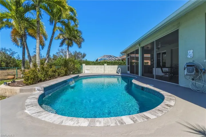 View of pool with a fenced backyard, a sunroom, and patio surround