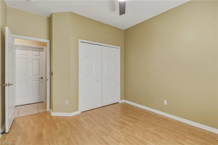Unfurnished bedroom with a closet, light wood-style flooring, and a ceiling fan